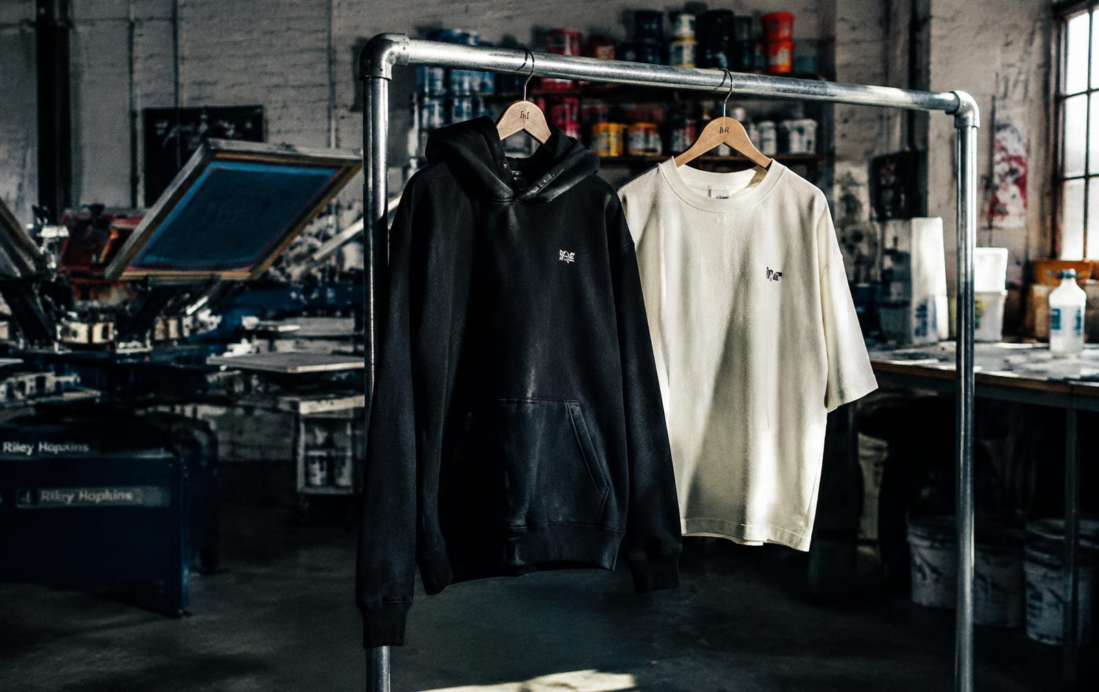 Heavyweight hoodie and tee on a rail in a screen printing studio